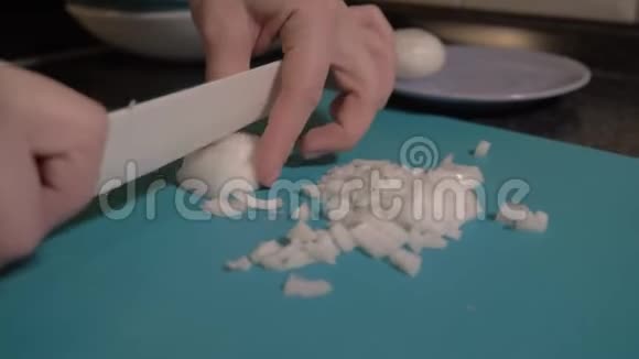 女孩在蓝色的切割板上用刀切弓快关门食物录像4K视频的预览图