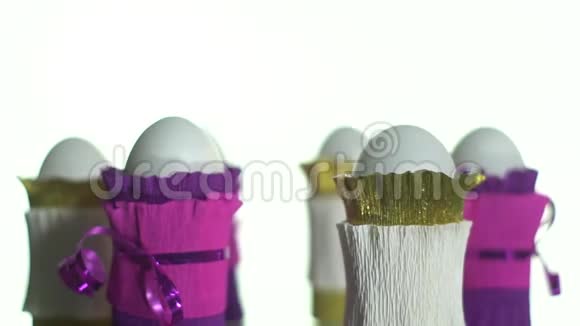 白色和紫色包裹的鸡蛋在展示桌上旋转视频的预览图