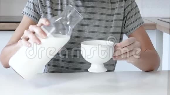 把牛奶倒入桌上的杯子里视频的预览图