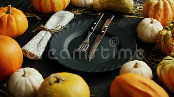 用南瓜包围的黑色盘子和餐具视频的预览图