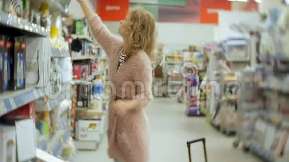 年轻女子站在超市货架附近挑选产品视频的预览图