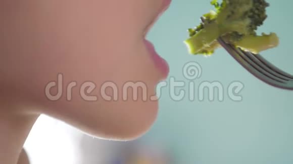 肖像小女孩年轻慢动作视频美女吃花椰菜素食吃西兰花的女孩视频的预览图