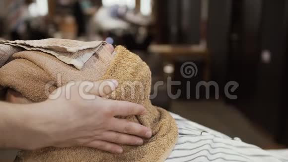 发型师用热毛巾遮住成熟男人的脸视频的预览图