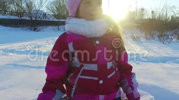 落在雪地里的小女孩冬天公园的孩子冬日阳光明媚视频的预览图