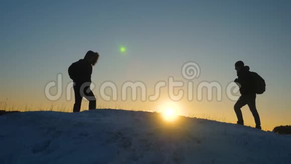 团队合作和胜利游客们来到白雪皑皑的山顶在夕阳的映衬下为胜利而欢欣鼓舞视频的预览图
