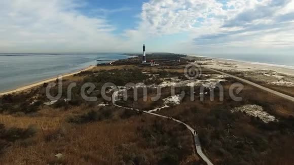 阳光明媚的冬日灯塔和海岸线的鸟瞰视频的预览图