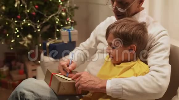 快乐的老人和他的孙子一起准备圣诞礼物视频的预览图