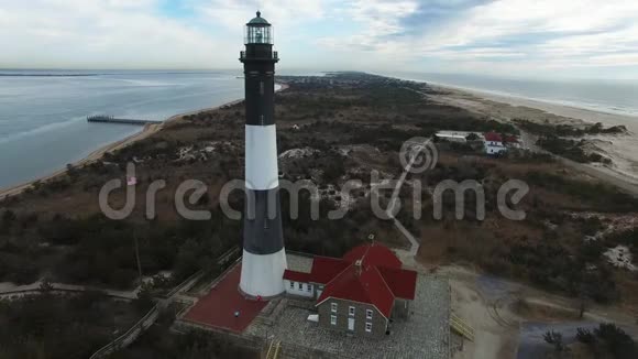 阳光明媚的冬日灯塔和海岸线的鸟瞰视频的预览图
