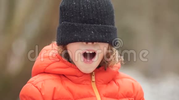 一个穿冬织帽子的男孩的肖像他闭上眼睛戴着帽子尖叫视频的预览图