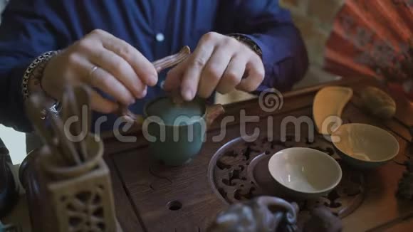 在传统的中国茶道中人们从茶壶到盖湾喝绿茶视频的预览图