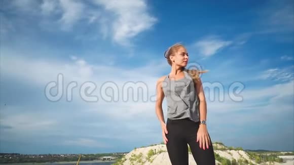 一个站在山上的女人喜欢大自然风吹着她视频的预览图