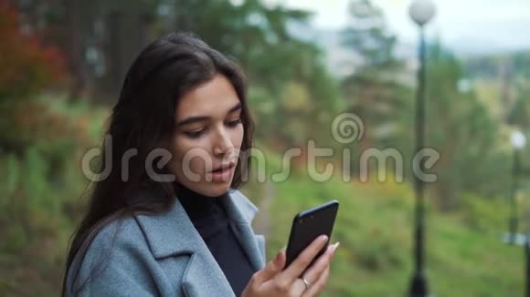 在公园附近用手机说话的女人视频的预览图