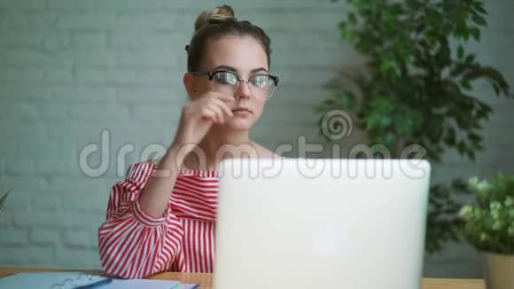 女人坐在笔记本电脑前的桌子旁女人的手放在键盘上视频的预览图