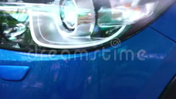 蓝色紧凑型SUV车型带有运动和现代设计的清洗从高压洗衣机喷水在洗车自助服务上视频的预览图
