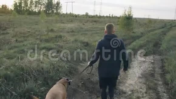 多利射中了一个年轻的运动男子他带着他的公牛獒犬在公园户外跑步并为他的宠物准备比赛视频的预览图