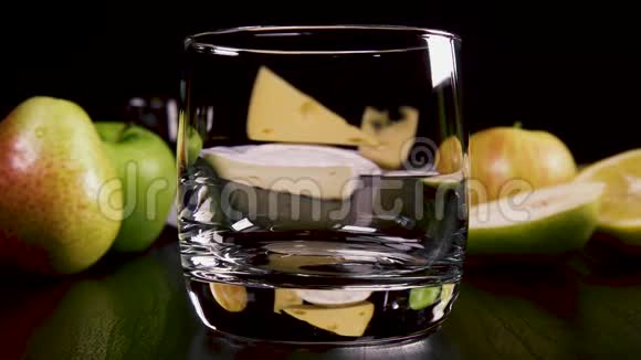 慢动作烈性酒精饮料倒入小吃附近的玻璃杯中视频的预览图