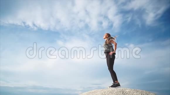 一个站在山上的女人喜欢大自然风吹着她视频的预览图