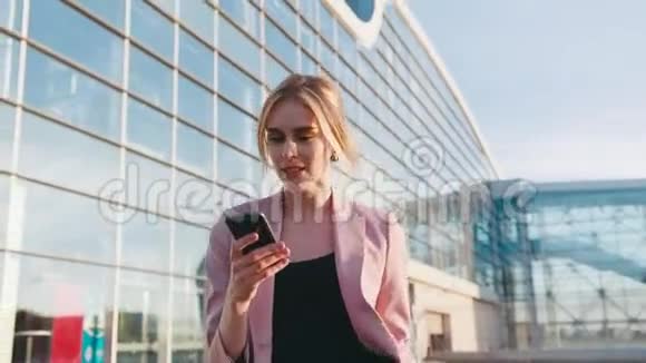 漂亮时尚的年轻女子急急忙忙地走到商务中心用她的手机得到信息感到惊讶视频的预览图