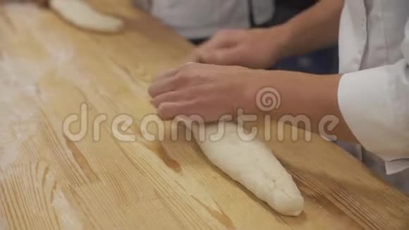 男人在面包店里把面团揉成法式面包视频的预览图