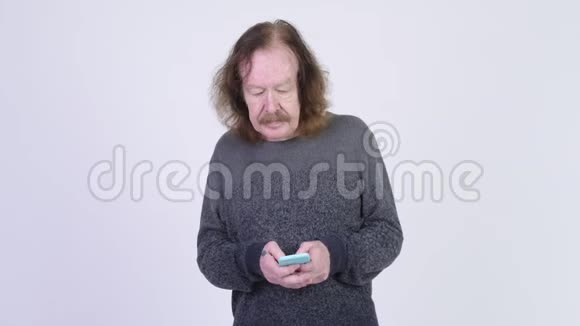 戴胡子的老人用电话看起来很震惊视频的预览图