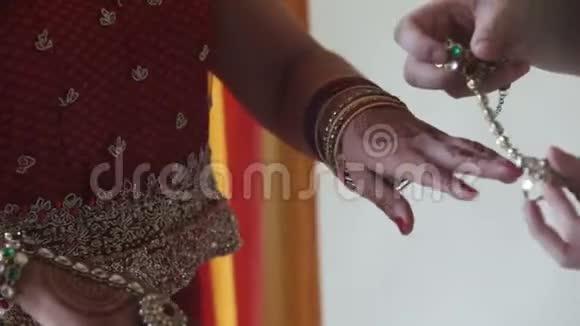 与Henna手上的贴身女礼服戒指和手镯视频的预览图