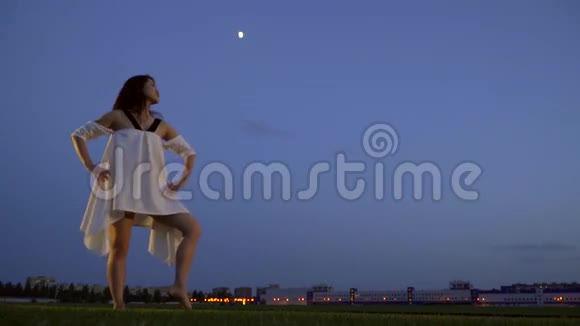 日本女孩穿着白色连衣裙修长的腿在晚上摆姿势动作缓慢视频的预览图