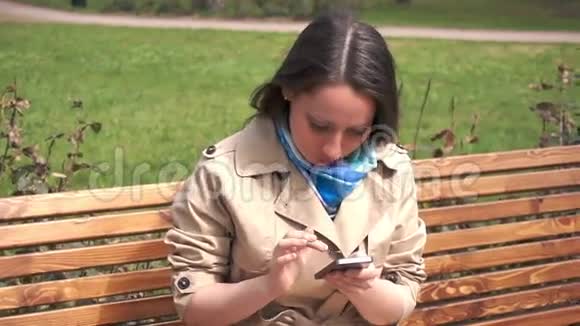 20岁的女孩坐在长凳上发短信视频的预览图