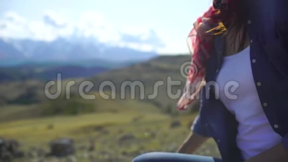 年轻女子的特写在群山的背景上打开一瓶橙汁4千克视频的预览图
