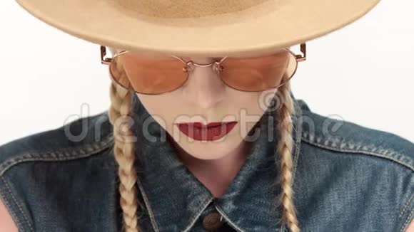 戴着两条辫子和玻璃的帽子的模特看起来像个牛仔女孩视频的预览图