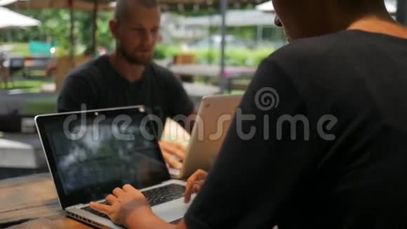 年轻人在咖啡馆的一张桌子上用笔记本电脑工作打字手特写高清慢运动泰国视频的预览图