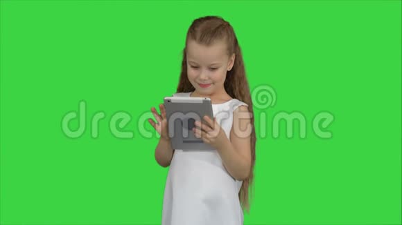 小女孩在绿色屏幕上使用平板电脑色度键视频的预览图