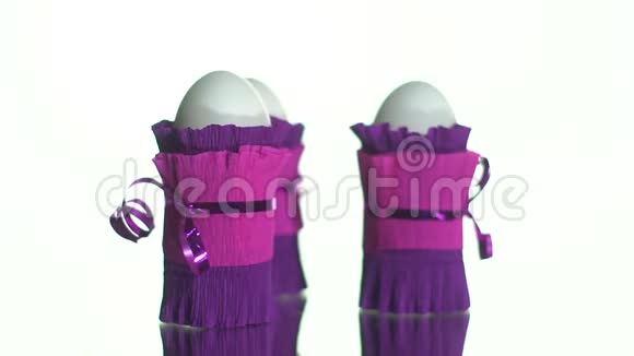 三个鸡蛋装在白色背景的转盘上的紫色包装纸上视频的预览图