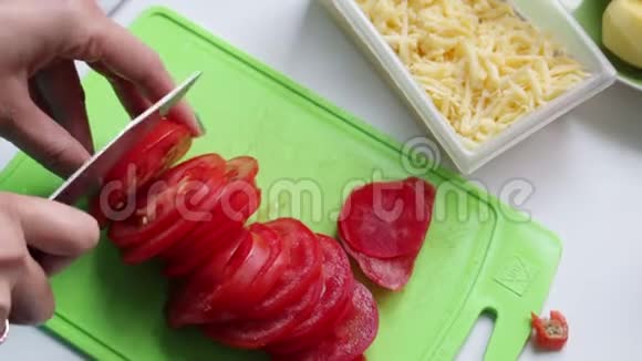 一个女人正在砧板上切西红柿接下来切好的奶酪和土豆视频的预览图
