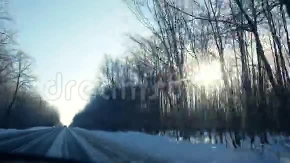 从车窗上可以看到一条阳光明媚的道路上行驶的景色视频的预览图