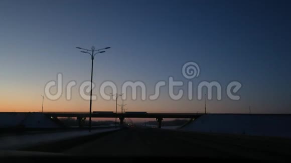 从车窗上可以看到汽车在昏暗的冬季道路上行驶在桥下行驶视频的预览图