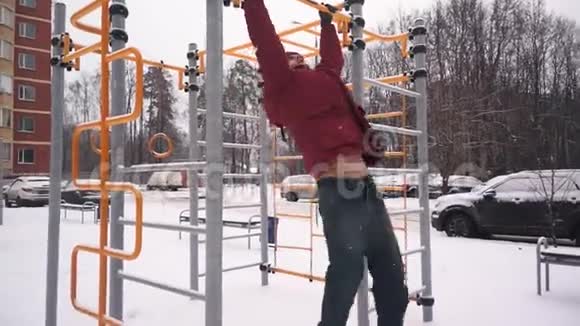 冬天一个男人在横杆上拉一个运动员在横杆上拉视频的预览图