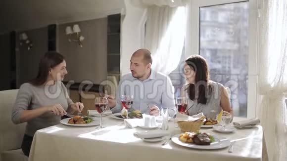 朋友们在餐厅用红酒在饭前品尝一顿美味的午餐在餐厅的陪伴下视频的预览图