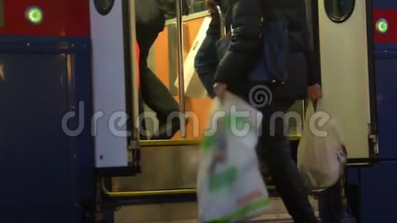 男子和妇女在购物后携带沉重的塑料袋进入城市电车视频的预览图