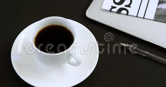 黑色背景4k的笔记本电脑眼镜报纸咖啡和笔视频的预览图