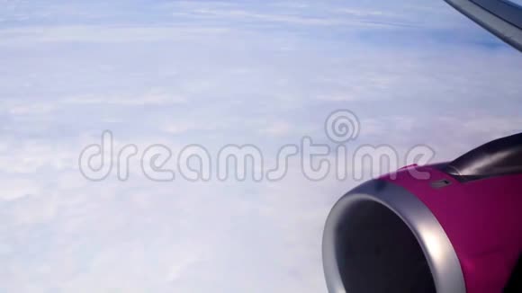 客机引擎和厚厚的白云通过飞机舷窗观看旅游视频的预览图
