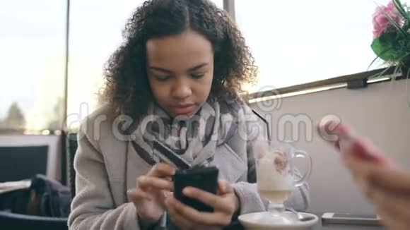 在街咖网上使用智能手机进行信用卡购物的混合种族女性特写镜头视频的预览图