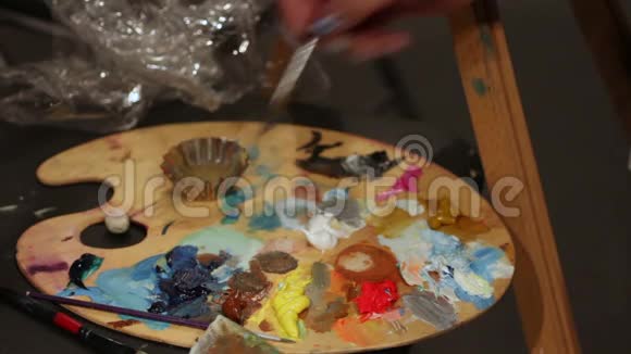 女人用油画颜料艺术工艺爱好在调色板上灌篮画笔视频的预览图