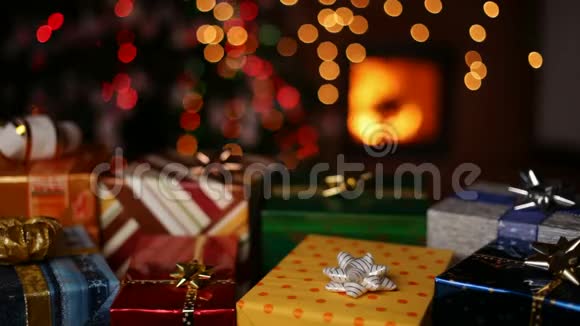 壁炉前的许多圣诞礼物和圣诞树上模糊的灯光视频的预览图