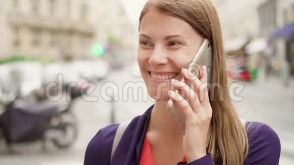 微笑的女商人站在街上在手机上交谈专业女性商务电话视频的预览图