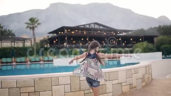 美丽的年轻女孩在游泳池附近开心快乐视频的预览图
