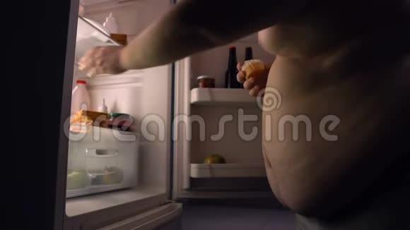 懒惰的肥胖单身汉从冰箱里吃垃圾食品喝啤酒卡路里视频的预览图