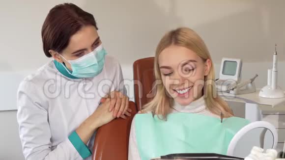 专业牙医和她的病人对着镜头微笑视频的预览图