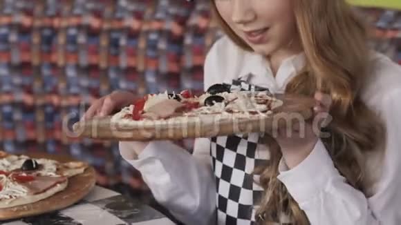 很年轻的女孩喜欢披萨的味道慢慢地视频的预览图