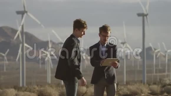 两个人在风车附近做工程视频的预览图