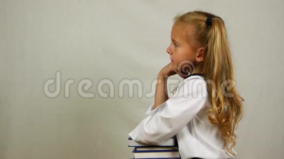 穿制服的女学生坐在书上对着镜头微笑侧视图视频的预览图